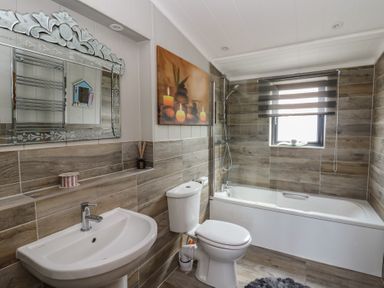 A bathroom with a bathtub and sink at Coogee View in Maenygroes near New Quay