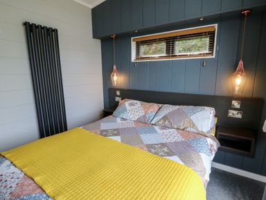 A bedroom with a bed and light fixtures at Coogee View in Maenygroes near New Quay