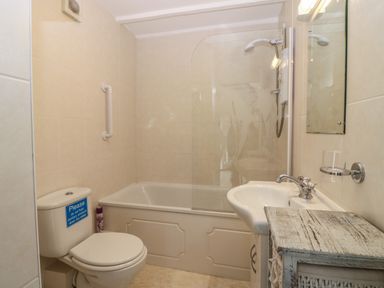 A bathroom with a toilet sink and bathtub with shower at The Haven in Norham