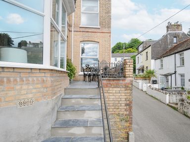 An outdoor patio area with a wrought iron table and chairs at Albert House in Looe