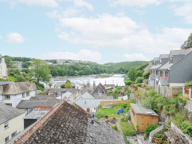 A view of rooftops and a river with hills in the background at Albert House in Looe