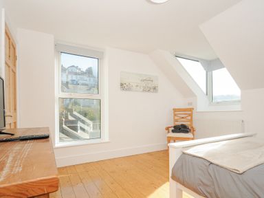 A bedroom with a wooden chair a bed and a wooden desk at Albert House in Looe