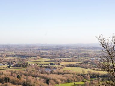A wide rural landscape with fields trees and scattered houses at Holly Cottage in Great Malvern