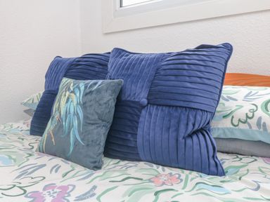 Pillows arranged on a bed with floral patterned bedding at Number 24 The Park in Kilkhampton