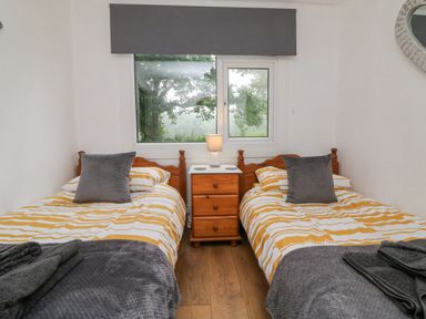 A bedroom with two single beds and a window at Number 24 The Park in Kilkhampton