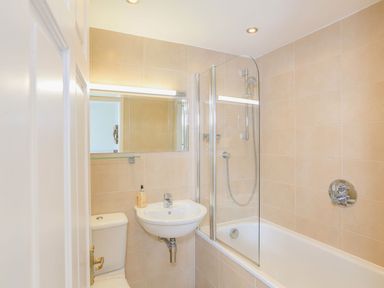 A bathroom with a toilet sink bathtub shower and mirror at 7 Island Quay in Salcombe