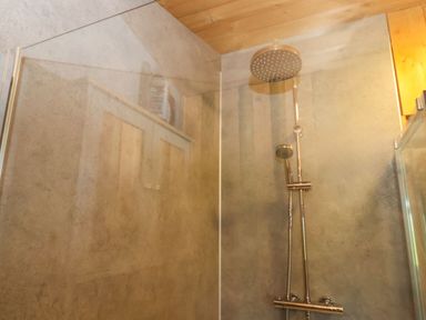 A shower area with a wall showerhead and handheld showerhead at Stag Lodge Holiday Retreat in Whitby