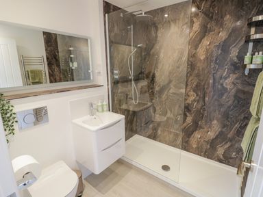 A bathroom with a walk in shower a white sink and toilet and a mirror at The Croft in Shipston On Stour