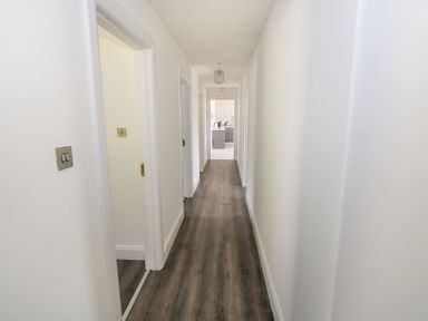 A hallway with wooden floor and white walls leading to a kitchen at Cushranny Mulranny County Mayo