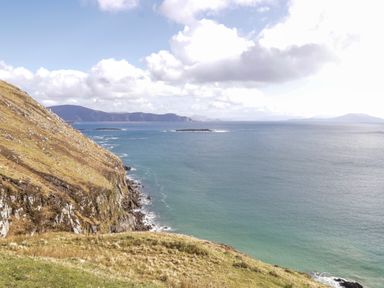 A coastal landscape with a rocky cliff on the left and the ocean extending to the horizon at Cushranny in Mulranny County Mayo