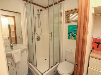 A bathroom with a corner shower enclosure a toilet and a sink with a towel at Templar Rise 16 - Devon Comfort Finlakes Holiday Park near Chudleigh
