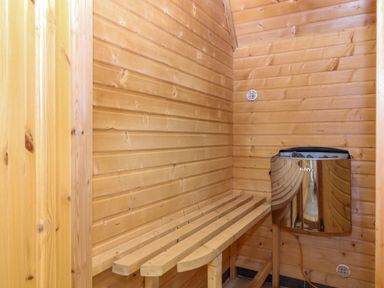 A wooden sauna room with a bench and a Harvia heater at Lodge 45 - Lazy Bear Finlakes Holiday Park near Chudleigh