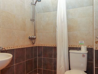 A bathroom with a showerhead curtain toilet and sink at Lodge 45 - Lazy Bear Finlakes Holiday Park near Chudleigh