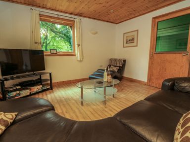A living room with a large window a glass coffee table a leather sofa a leather armchair and a flat screen tv at Lodge 58 - Oak Tree Lodge Finlakes Holiday Park near Chudleigh