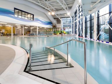 An indoor swimming pool with steps into the water and a water play area with slides at Lodge 58 - Oak Tree Lodge in Finlakes Holiday Park near Chudleigh