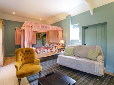 A bedroom with a bed and sofa at Clock Tower in Stowmarket