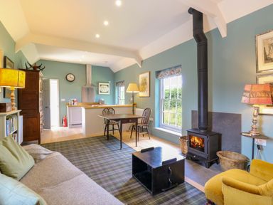 A living room with a sofa and dining table at Clock Tower in Stowmarket