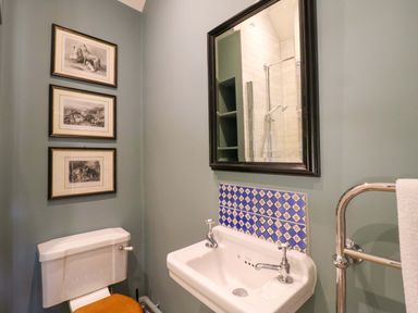 A bathroom with a sink, toilet, and wall art at Clock Tower in Stowmarket