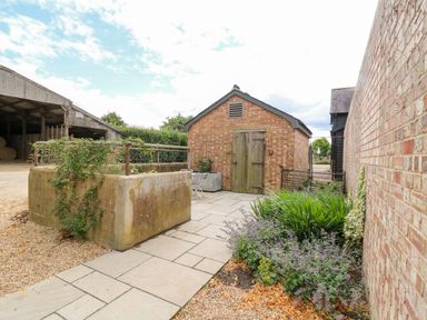 An outdoor area with a path and a brick building at Clock Tower in Stowmarket