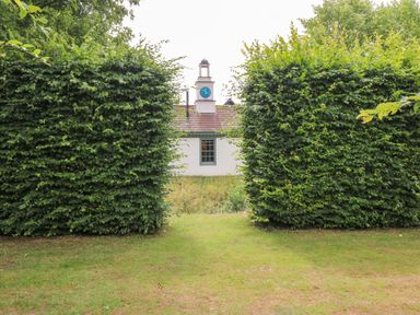 View of a building framed by hedges at Clock Tower in Stowmarket