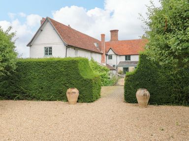 An outdoor view of a house with hedges and pots at Clock Tower in Stowmarket
