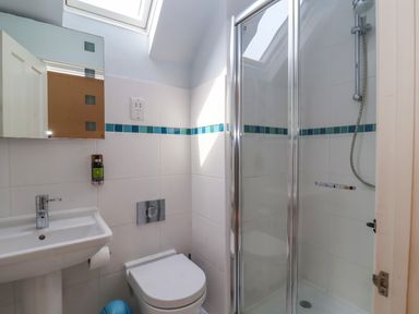 A bathroom with a sink toilet and shower stall at Samphire House in Southwold