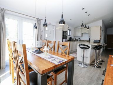 A dining area with a wooden table and chairs at Angel Lodge - No 27 Fornham St Genevieve near Bury St Edmunds