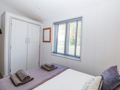 A bedroom with a bed and wardrobe at Angel Lodge - No 27, Fornham St Genevieve near Bury St Edmunds