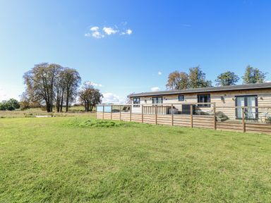 An outdoor area with a building and a fence at Angel Lodge - No 27 Fornham St Genevieve near Bury St Edmunds