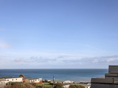 A coastal view with houses and the sea under a clear sky at Sandy Bay Retreat in Benllech