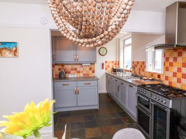 A kitchen with cabinets and appliances at Combe View Ilfracombe