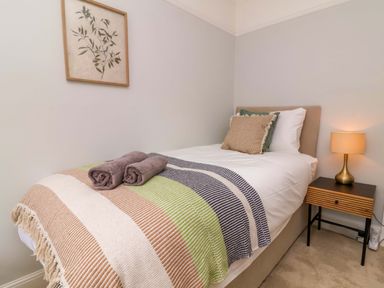 A bedroom with a bed and a lamp at Combe View in Ilfracombe