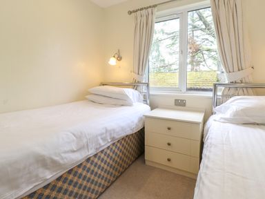 A small bedroom with two single beds and a drawer unit between them at Lodge 3 At Pound Farm in Crook near Kendal