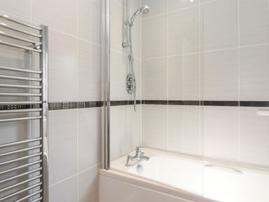 A bathroom with a bathtub shower combination and a heated towel rail at Lodge 7 At Pound Farm in Crook near Kendal