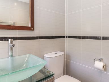 A bathroom with a glass sink toilet mirror and toilet paper holder at Lodge 7 At Pound Farm in Crook near Kendal