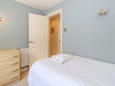 A bedroom with a bed white door and a chest of drawers at Lodge 7 At Pound Farm in Crook near Kendal