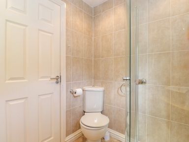 A bathroom with a white toilet beside a glass shower enclosure at Lodge 7 At Pound Farm Crook near Kendal