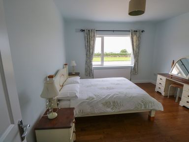 A bedroom with bed bedside tables and a dressing table with mirror at Cois Leice in Cushlecka near Mulranny County Mayo