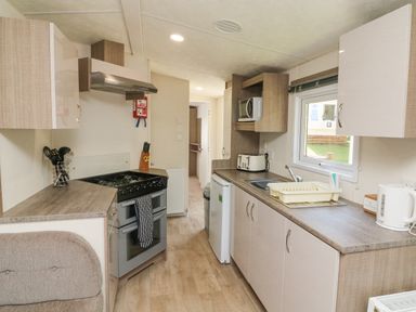 A kitchen with stove microwave toaster and kettle at 23 Manleigh Park in Combe Martin