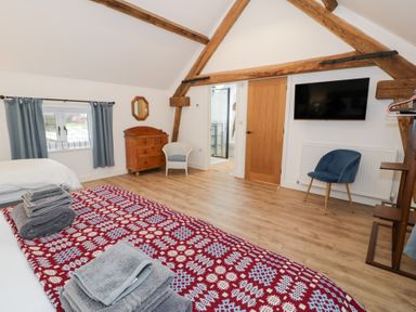 A bedroom with a bed and furniture at Y Stabl in Cerrigydrudion