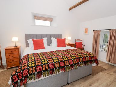 A bedroom with a bed and nightstands at Y Stabl in Cerrigydrudion