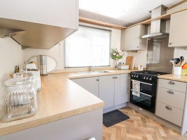 A kitchen with wooden countertops stove sink and cabinets at Saorsa in St Fillans