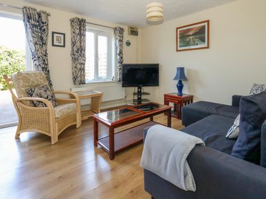 A living room with a sofa armchair coffee table and television at 74 Reap Lane in Southwell near Weston