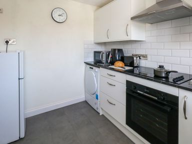 A kitchen with white cabinets black countertop and white tiled backsplash at 74 Reap Lane Southwell near Weston