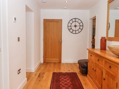 A hallway with a clock and wooden furniture at Lower Moorwood in Moorwood near Bovey Tracey