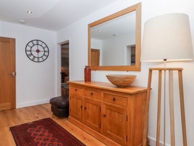 A hallway with a clock and lamp at Lower Moorwood in Moorwood near Bovey Tracey