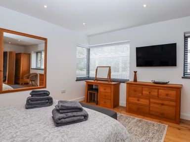 A bedroom with a bed and dresser at Lower Moorwood Moorwood near Bovey Tracey