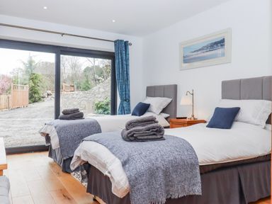 A bedroom with two beds and a view of the garden at Lower Moorwood in Moorwood near Bovey Tracey