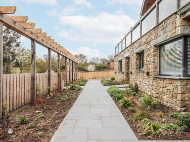 A garden pathway beside a house with a pergola at Lower Moorwood near Bovey Tracey