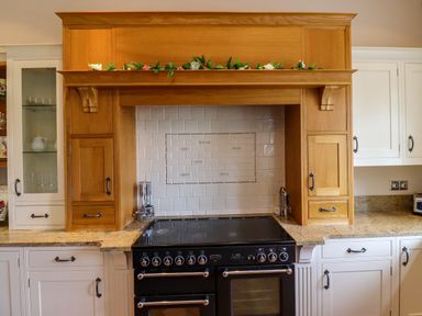 A kitchen stove with wooden cabinets and white tiled backsplash at North Wing in Middleton Hall Estate near Belford